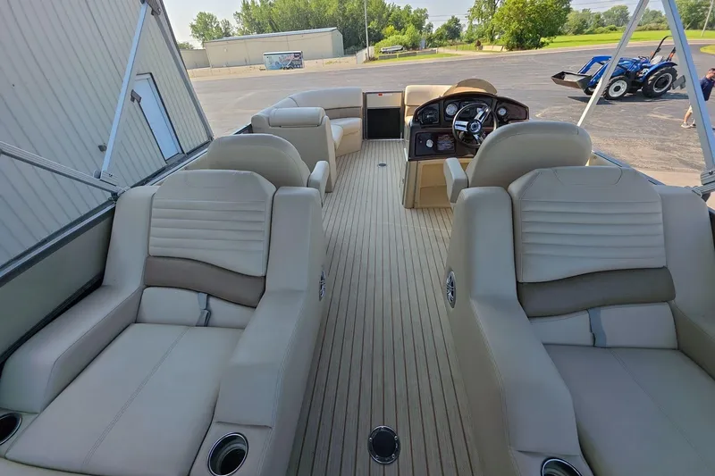 Slide: The Image of Interior of 2015 Crest III 230 SL pontoon boat with beige seating and steering console. - 9