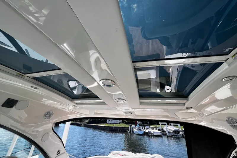 Slide: The Image of Interior view of 2012 Sea Ray 500 Sundancer yacht with sunroof and water backdrop. - 13