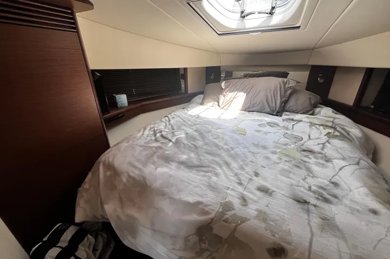 Slide: The Image of Cozy bedroom interior of 2012 Sea Ray 500 Sundancer yacht with skylight and elegant bedding. - 25