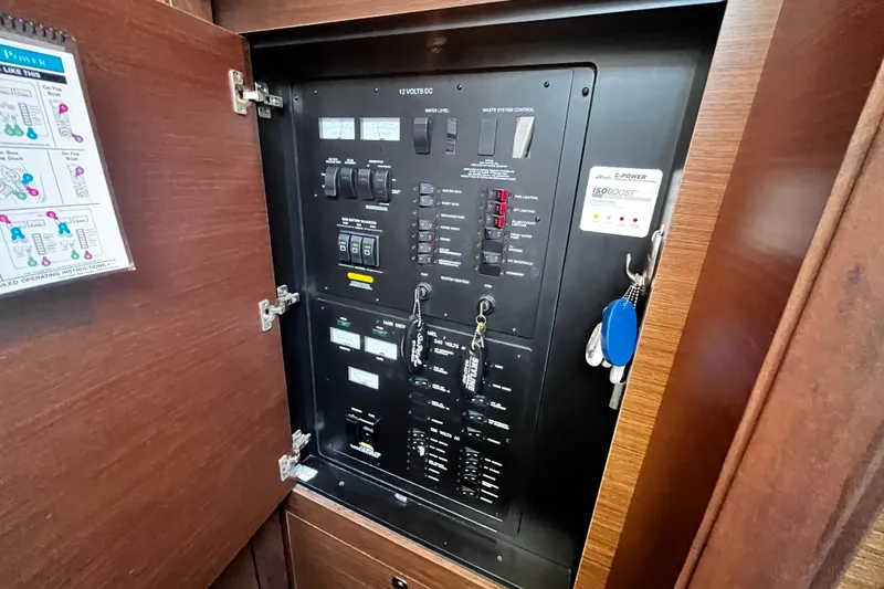 Slide: The Image of Electrical panel inside 2012 Sea Ray 500 Sundancer yacht, featuring control switches and keys. - 29