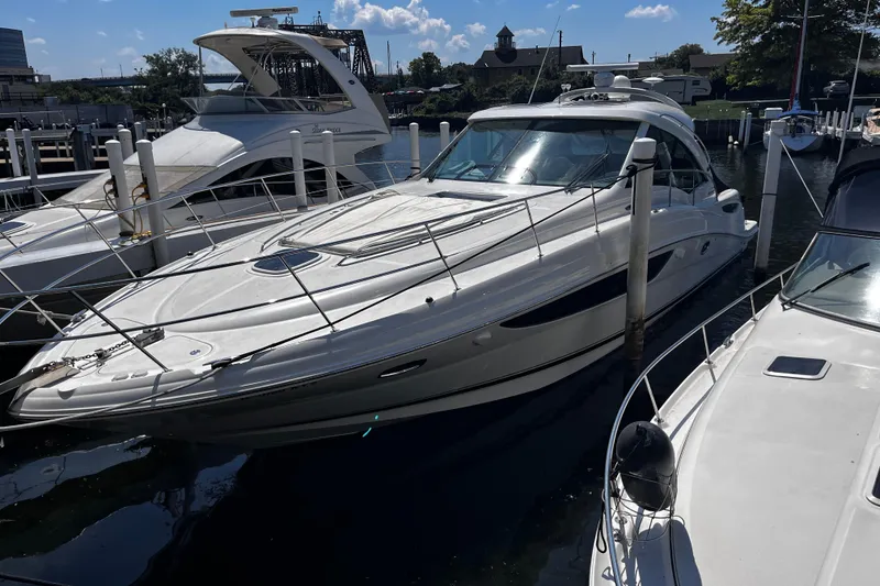 Slide: The Image of 2012 Sea Ray 500 Sundancer yacht docked at marina under clear blue sky. - 3