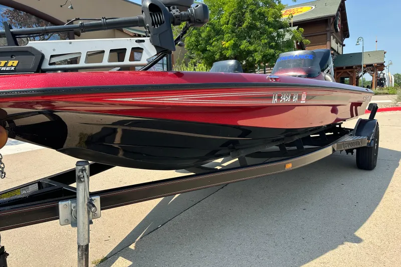 Slide: The Image of 1999 Champion 193 DCX boat on trailer, red and black, parked outdoors. - 2