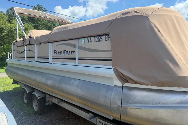 Slide: The Image of 2004 Parti Kraft Admiral 220 RE pontoon boat with tan cover on trailer. - 1
