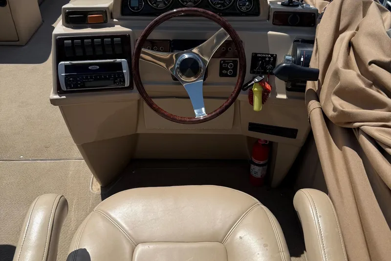 Slide: The Image of 2004 Parti Kraft Admiral 220 RE boat dashboard with steering wheel and controls. - 23