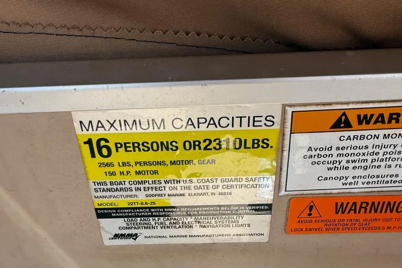 Slide: The Image of 2004 Parti Kraft Admiral 220 RE capacity label, 16 persons or 2310 lbs, safety warnings. - 25