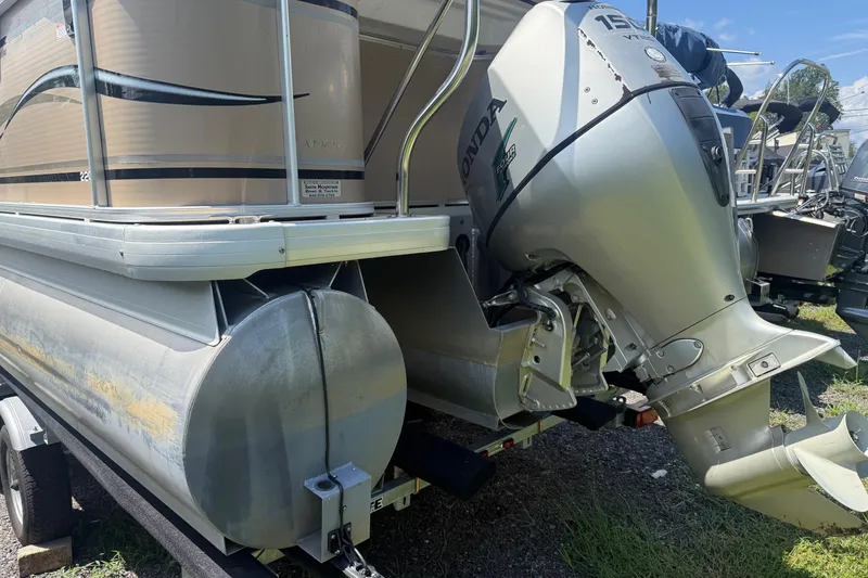 Slide: The Image of 2004 Parti Kraft Admiral 220 RE pontoon boat with Honda outboard motor, parked on trailer. - 4