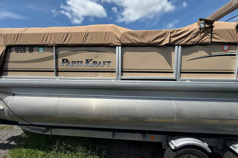Slide: The Image of 2004 Parti Kraft Admiral 220 RE pontoon boat with tan cover under blue sky. - 6