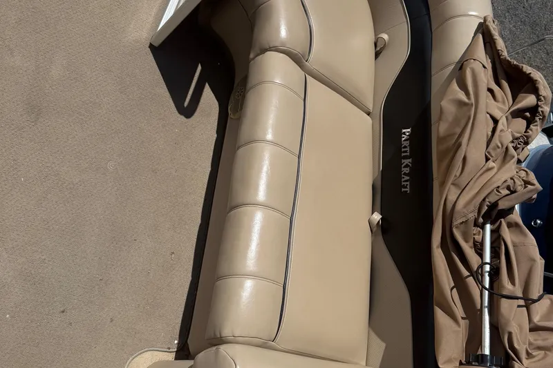 Slide: The Image of 2004 Parti Kraft Admiral 220 RE boat interior with beige seating and cover. - 8