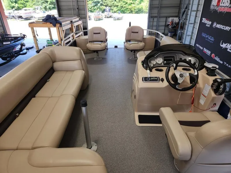 Slide: The Image of 2017 Sun Tracker FISHIN' BARGE® 24 DLX interior with beige seating and control console. - 7