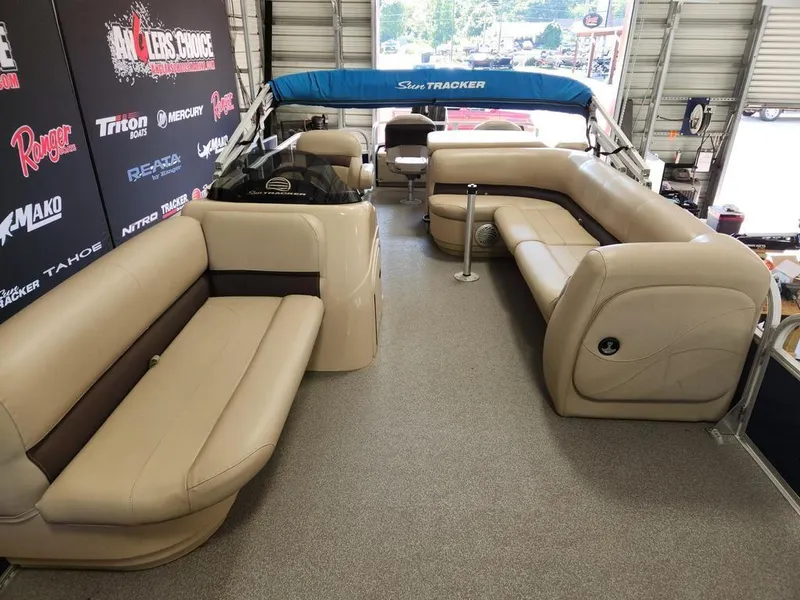 Slide: The Image of 2017 Sun Tracker FISHIN' BARGE® 24 DLX interior with beige seating and blue canopy. - 9
