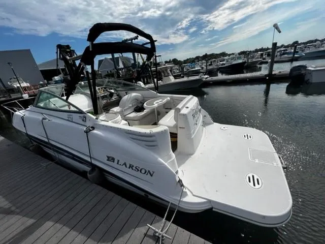 Slide: The Image of 2010 Larson Cabrio 274 boat docked at marina under partly cloudy sky. - 17