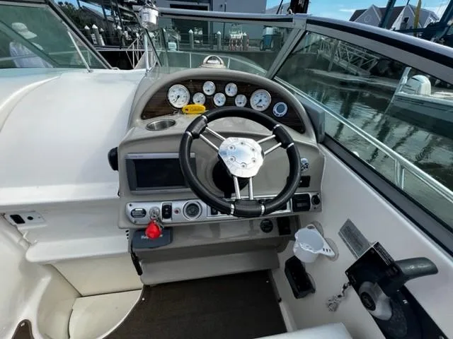 Slide: The Image of 2010 Larson Cabrio 274 boat dashboard with steering wheel and gauges. - 20