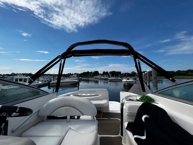 Slide: The Image of 2010 Larson Cabrio 274 boat docked at marina under clear blue sky. - 21