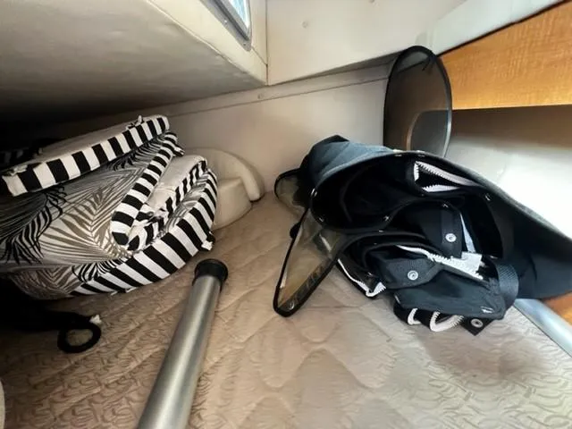 Slide: The Image of Interior storage space of a 2010 Larson Cabrio 274 boat with folded items and equipment. - 22