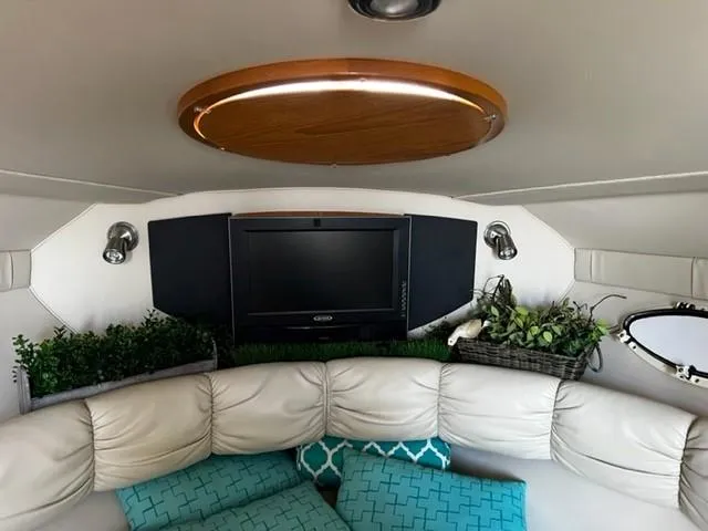 Slide: The Image of Interior of 2010 Larson Cabrio 274 with TV, plants, and cushioned seating. - 27