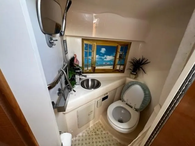 Slide: The Image of Compact bathroom in a 2010 Larson Cabrio 274 boat with scenic window decor. - 28