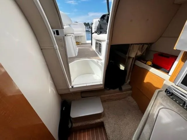 Slide: The Image of Interior view of a 2010 Larson Cabrio 274 boat, showing cabin and deck access. - 29