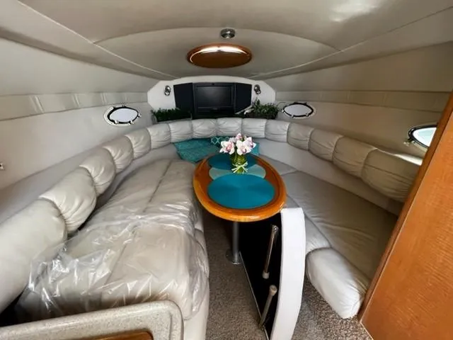 Slide: The Image of Interior of 2010 Larson Cabrio 274 boat with plush seating and a central table. - 31