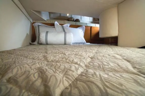 Slide: The Image of Cozy cabin interior of 2010 Larson Cabrio 274 with patterned bedding and pillows. - 6