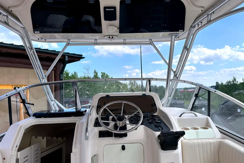 Slide: The Image of 2000 Grady-White Express 265 boat cockpit with steering wheel and navigation equipment. - 15