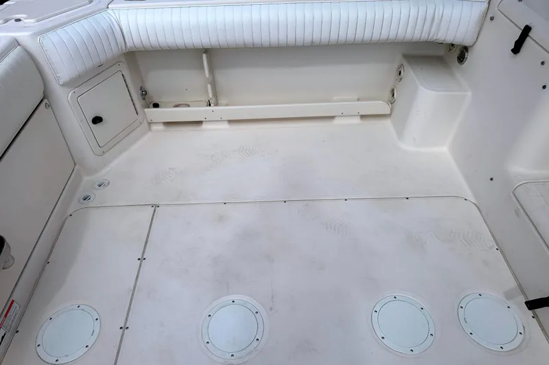 Slide: The Image of Spacious deck of 2000 Grady-White Express 265 boat with white seating and storage compartments. - 21