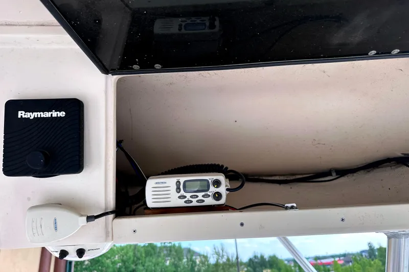 Slide: The Image of 2000 Grady-White Express 265 boat dashboard with Raymarine equipment and radio. - 25
