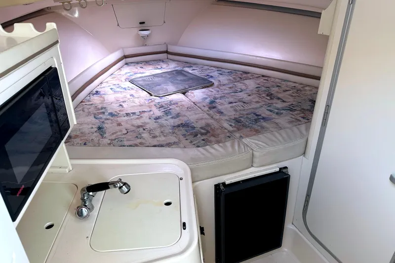 Slide: The Image of 2000 Grady-White Express 265 cabin interior with kitchenette and sleeping area. - 26