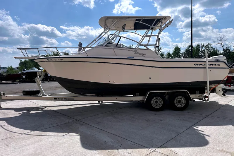 Slide: The Image of 2000 Grady-White Express 265 boat on trailer under a sunny sky. - 6