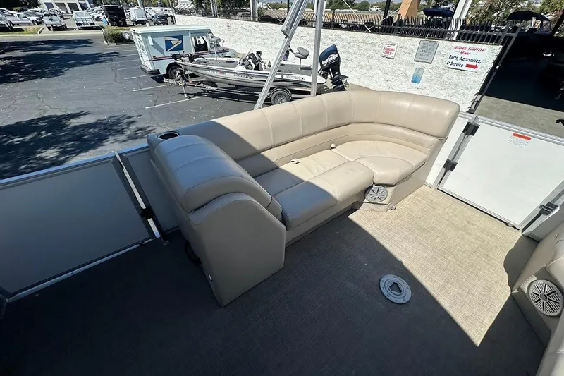 Slide: The Image of 2017 Ranger Reata 220C pontoon boat with beige seating in a parking lot. - 13