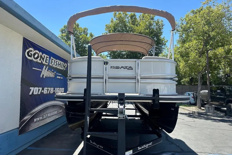 Slide: The Image of 2017 Ranger Reata 220C pontoon boat on trailer, parked outside dealership. - 2