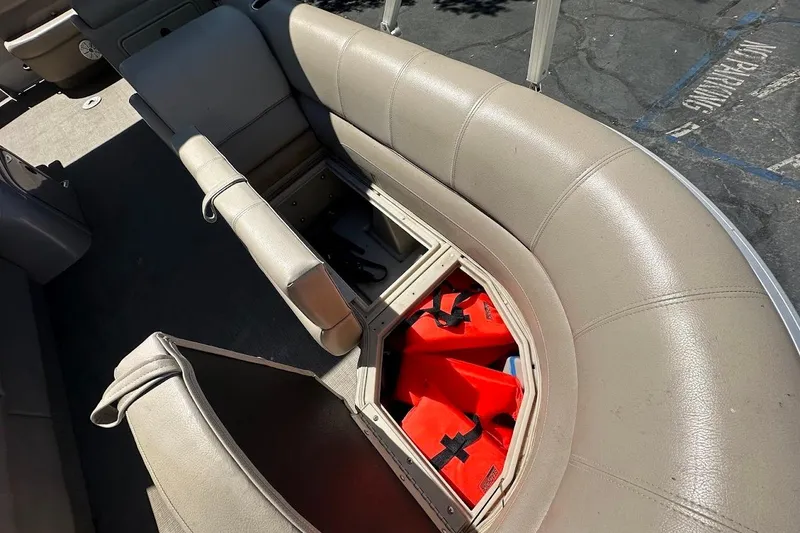 Slide: The Image of 2017 Ranger Reata 220C boat interior with open storage compartment and life jackets. - 28