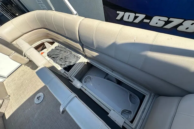 Slide: The Image of 2017 Ranger Reata 220C boat interior with open storage compartments and cushioned seating. - 29