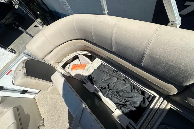 Slide: The Image of 2017 Ranger Reata 220C boat interior with open storage compartment and beige seating. - 30