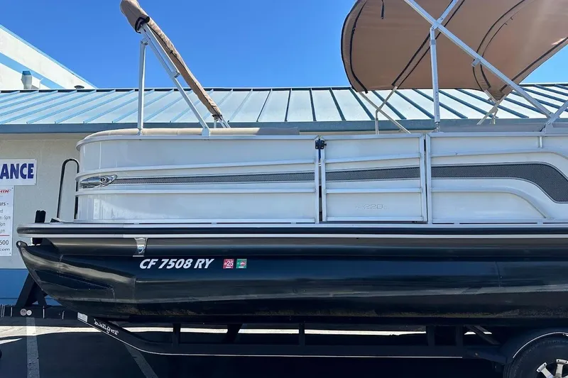Slide: The Image of 2017 Ranger Reata 220C pontoon boat with canopy, parked on a trailer. - 5