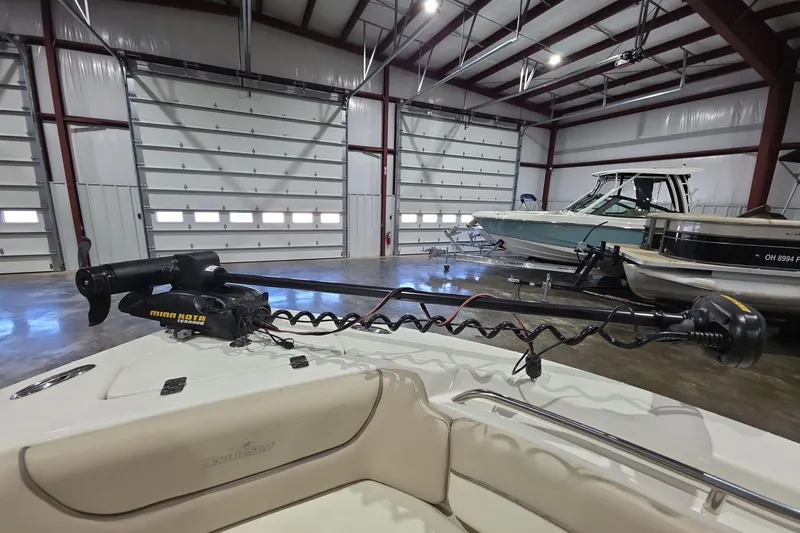 Slide: The Image of 2017 NauticStar 2302 Legacy boat with Minn Kota trolling motor in a storage facility. - 11