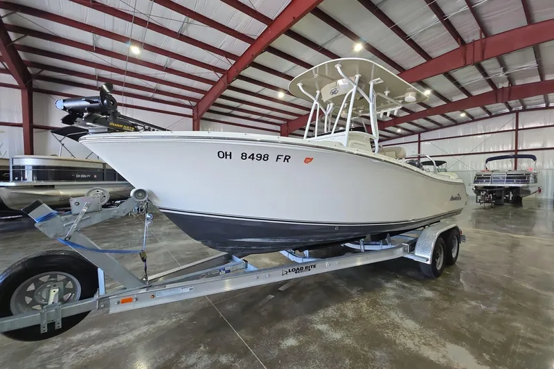 Slide: The Image of 2017 NauticStar 2302 Legacy boat on trailer in indoor storage facility. - 2