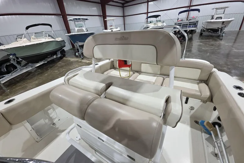 Slide: The Image of 2017 NauticStar 2302 Legacy boat interior with beige seating in a showroom. - 9