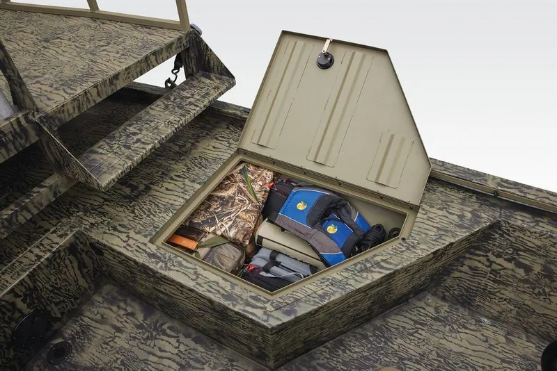 Slide: The Image of Storage compartment of 2026 Tracker GRIZZLY® 2072 CC Sportsman boat with gear and life jackets. - 26