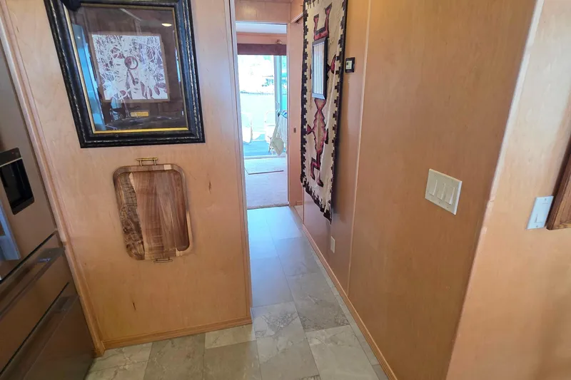 Slide: The Image of Hallway in 2015 Sailabration 64 houseboat with framed art and decorative wall hanging. - 18