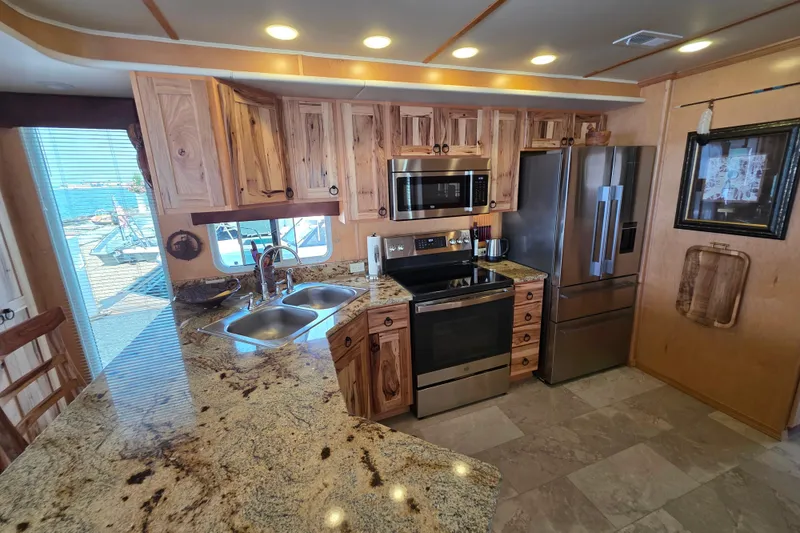 Slide: The Image of Luxurious kitchen in 2015 Sailabration 64 houseboat with granite countertops and stainless steel appliances. - 26