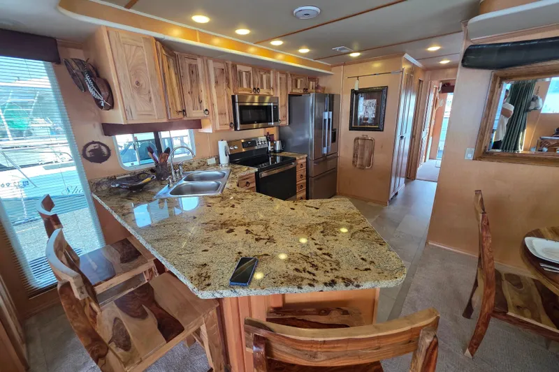 Slide: The Image of Luxurious 2015 Sailabration 64 yacht kitchen with granite countertops and wooden cabinetry. - 28