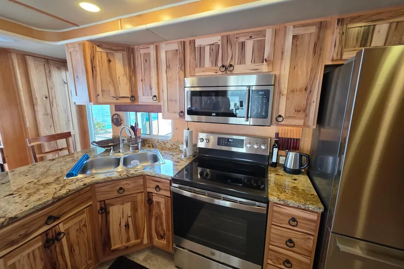 Slide: The Image of Modern kitchen in 2015 Sailabration 64 houseboat with wood cabinets and stainless steel appliances. - 30