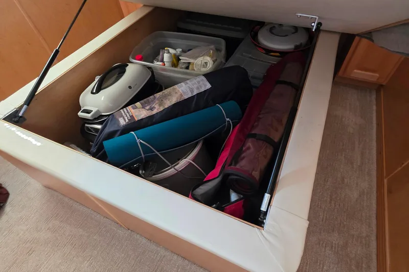 Slide: The Image of Under-seat storage in 2015 Sailabration 64 boat, containing camping and cooking gear. - 33