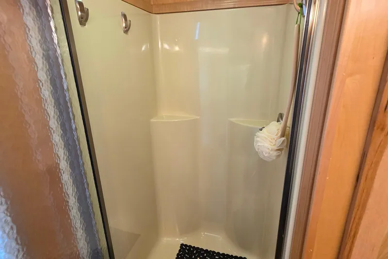Slide: The Image of Shower area in 2015 Sailabration 64 boat, featuring hooks and a loofah. - 39