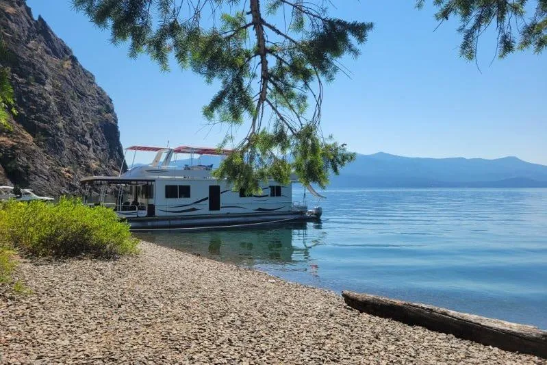 Slide: The Image of Houseboat Sailabration 64 (2015) moored by a rocky lakeshore with scenic mountain views. - 47
