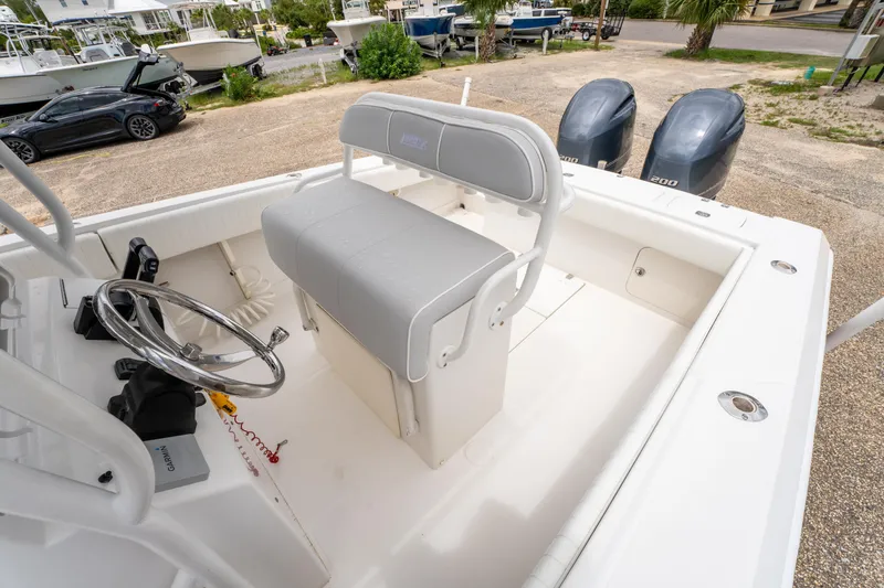 Slide: The Image of 2004 Jupiter 27fs boat interior with steering wheel and dual outboard motors. - 14