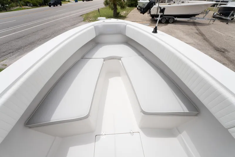 Slide: The Image of 2004 Jupiter 27fs boat interior with white cushioned seating and open deck. - 23