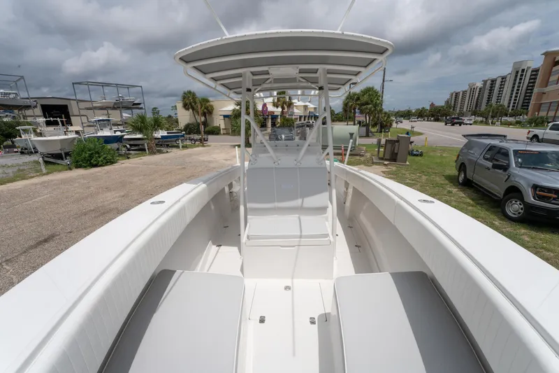 Slide: The Image of 2004 Jupiter 27fs boat with spacious deck, parked near marina under cloudy sky. - 25