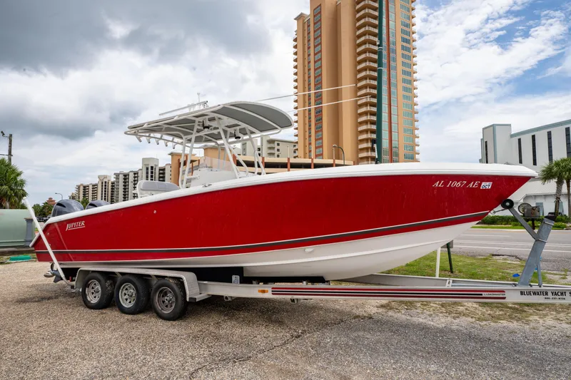 Slide: The Image of Red 2004 Jupiter 27fs boat on trailer, urban background, cloudy sky. - 4
