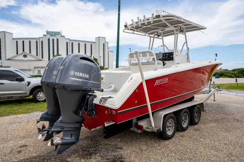 Slide: The Image of Red 2004 Jupiter 27fs boat on trailer with dual Yamaha engines, parked outdoors. - 6